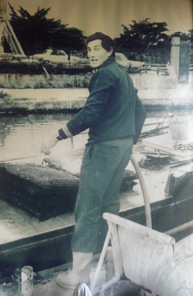Archive familiale : ostréiculteur sur le chaland, sacs d'huîtres.
